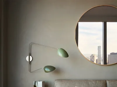 A minimalist bedroom featuring a contemporary bedside lamp and a large window overlooking a cityscape.
