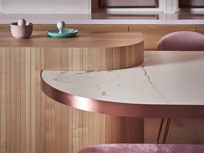 A modern kitchen with wooden cabinets and marble countertops.