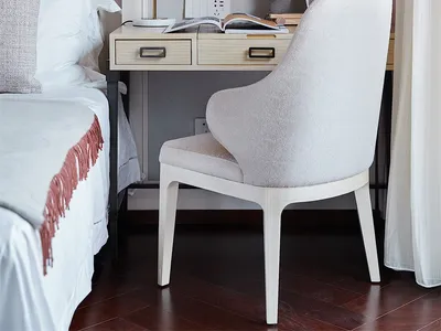 A minimalist office desk space featuring a wooden desk with a brass lamp, a unicorn plush toy, and an open book, alongside a