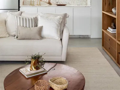 A minimalist living room with a white marble kitchen counter and modern furniture