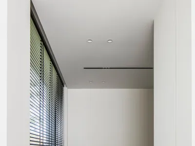 A minimalist home office with concrete flooring, a wooden desk, and a chair.