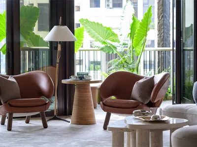 Modern living room with industrial design features, wooden furniture, and greenery