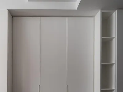 A minimalist bedroom featuring white cabinets and wooden furniture.