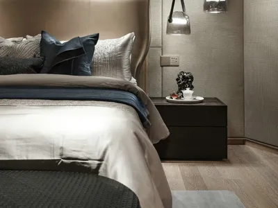 A modern bedroom with fabric bedding and glass pendant lights.