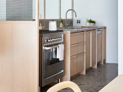 Modern minimalist kitchen featuring stainless steel appliances, wooden cabinets, and glass elements.