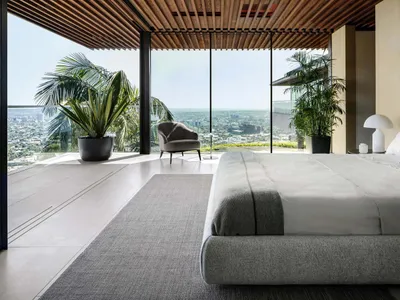 A modern bedroom featuring a balcony overlooking a cityscape.