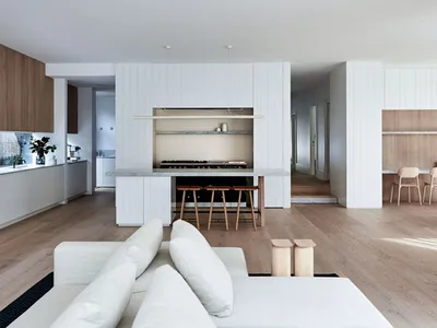 Modern living room and kitchen with open-concept design, featuring wood and marble materials