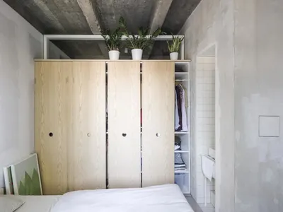A minimalist bedroom with an open wooden closet