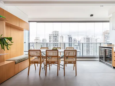 Modern, minimalist residential kitchen featuring wooden elements and a large window overlooking a cityscape.