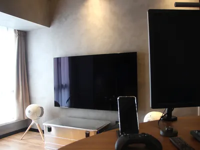 A home office workstation featuring a wooden desk, a monitor, a keyboard, and a speaker.