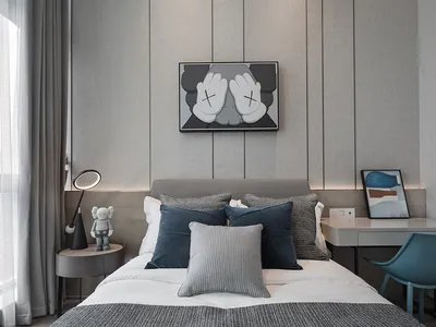 A minimalist bedroom with a grey bed, black and white accents, and a desk with a blue chair.