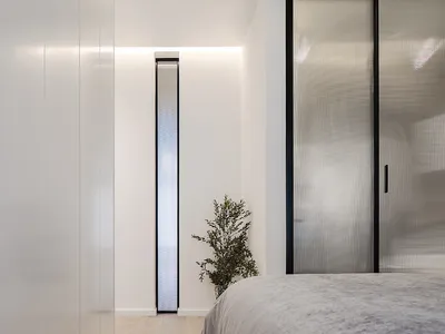 Modern minimalist bedroom featuring glass and metal elements.