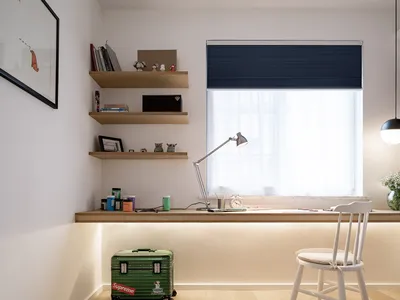 A modern home office with a wooden desk, blue curtains, and white shelves.
