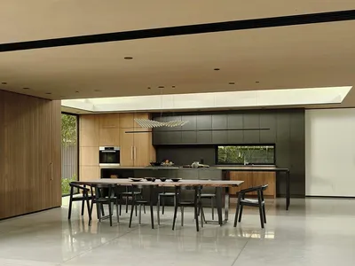 Large, open-plan, minimalist residential kitchen with black and white color scheme and metallic finishes.