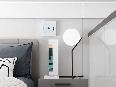 Minimalist bedroom featuring a bedside table, lamp, and decorative items.