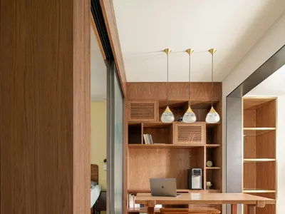 A minimalist home office featuring a wooden desk and shelves.