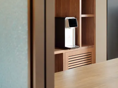 Modern kitchen featuring wooden shelving and a sleek water dispenser.