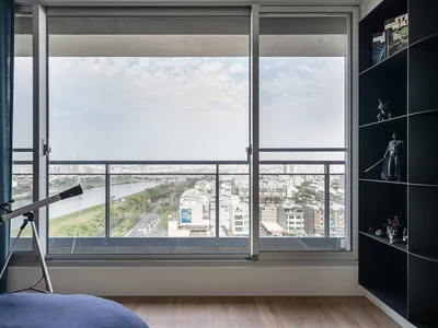 Modern bedroom featuring a glass telescope and a view of a cityscape