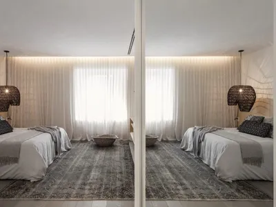 A modern minimalist bedroom with wooden floors, two beds, and large windows.
