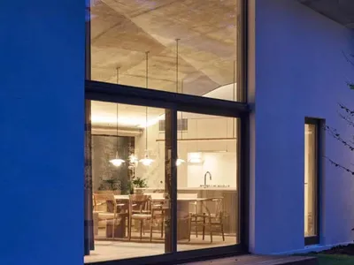 Modern minimalist kitchen interior featuring sleek concrete and glass materials.