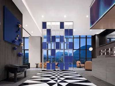 Modern hotel lobby featuring glass partitions and metal chairs