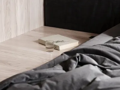 現代臥室場景，展示簡約床頭櫃，採用霧面材質與俐落設計。