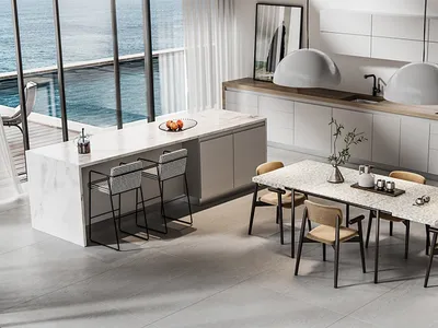 Modern kitchen with marble countertops, white cabinets, and a dining table with beige chairs.