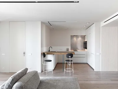 Modern minimalist kitchen with a wooden countertop and white appliances.