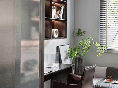 Modern, organized office space featuring a wooden shelf with glass vases, a leather chair, and a small green plant.