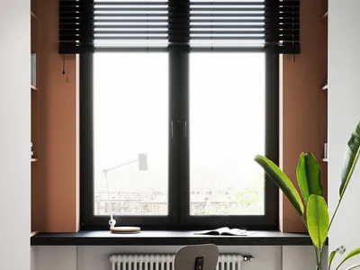 簡約風格的居家辦公室，設有大型窗戶搭配黑色百葉簾、內建式書桌區域，以及一張現代風格的椅子。