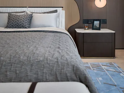 A modern minimalist bedroom featuring wooden materials and a cozy atmosphere.