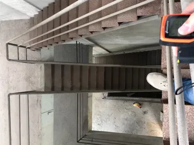 混凝土樓梯搭配金屬扶手，地面上有一小塊食物。