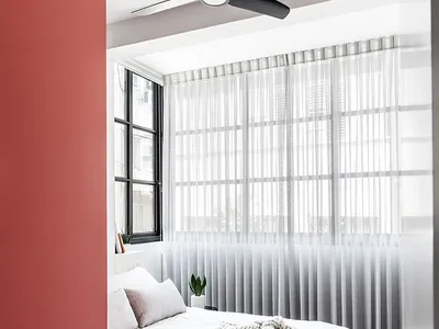 A modern minimalist bedroom featuring a bed with white bedding, wood floors, and a metal frame.