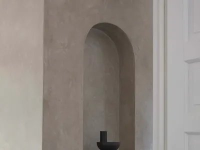 A modern minimalist living room featuring a single piece of furniture made from dark concrete, positioned against a plain con