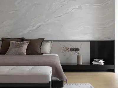 A modern bedroom with neutral-toned walls, bedding, and furniture, featuring a minimalist design style.