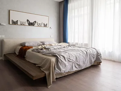 Minimalist bedroom featuring a bed with cotton and linen blend fabric on a wooden platform, with soft lighting and soft furni
