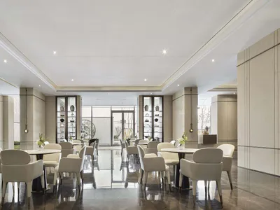 Modern hotel lobby with marble countertops, leather chairs, and glass displays.
