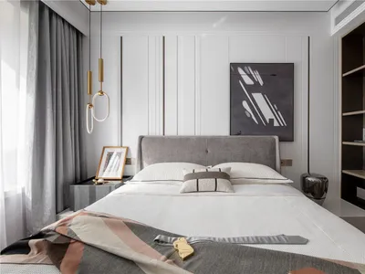 A modern minimalist bedroom with a white bed, grey headboard, and abstract wall art.