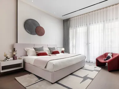 Modern minimalist bedroom featuring a bed with a fabric headboard and glass elements.