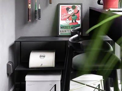 A home office with industrial design elements, including concrete walls, metal furniture, and skateboard decks hanging on the