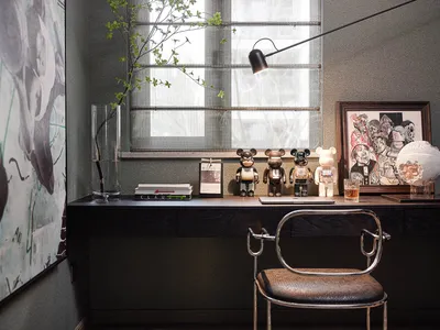 A modern home office with a desk, chair, and various decorative items.