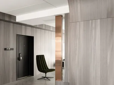 A modern home office with dark wood walls and a sleek, green swivel chair.