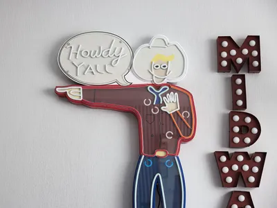 A neon sign featuring a cowboy with a speech bubble saying 'Howdy Y'all'.