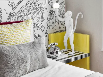 A modern bedroom featuring a unique light sculpture in the shape of a monkey holding a light bulb.