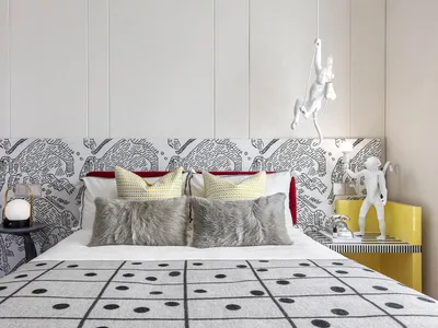A modern bedroom interior featuring a patterned upholstered headboard and decorative pillows, with a 3D-rendered design.