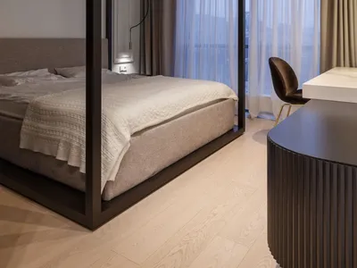 A modern bedroom featuring a frame bed with a minimalist design and a neutral color palette.