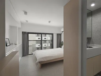 極簡臥室擁有混凝土牆面與玻璃門，配有白色床具及木質床頭板。