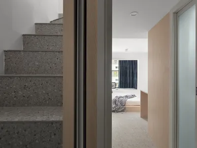 A modern bedroom with concrete stairs and a minimalist design.