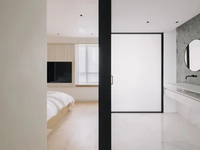 簡約臥室，配有木質床架與黑色木質床頭板、水磨石地板，以及一扇大窗