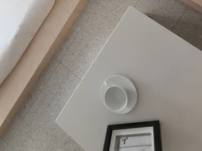 簡約臥室擺放白色寢具與木質家具。